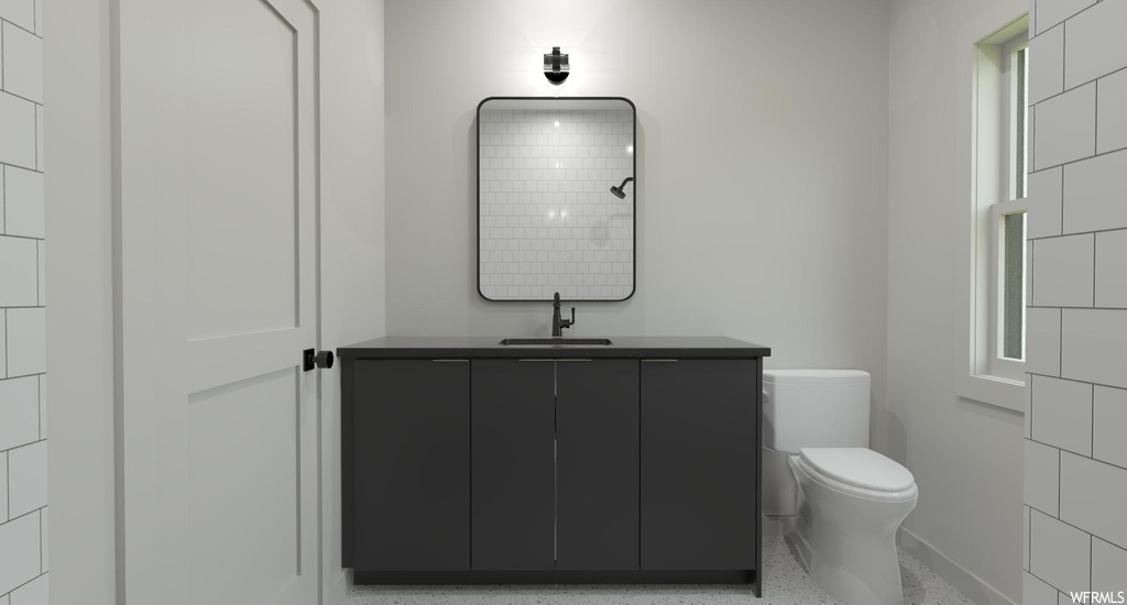 Bathroom with toilet and vanity with extensive cabinet space