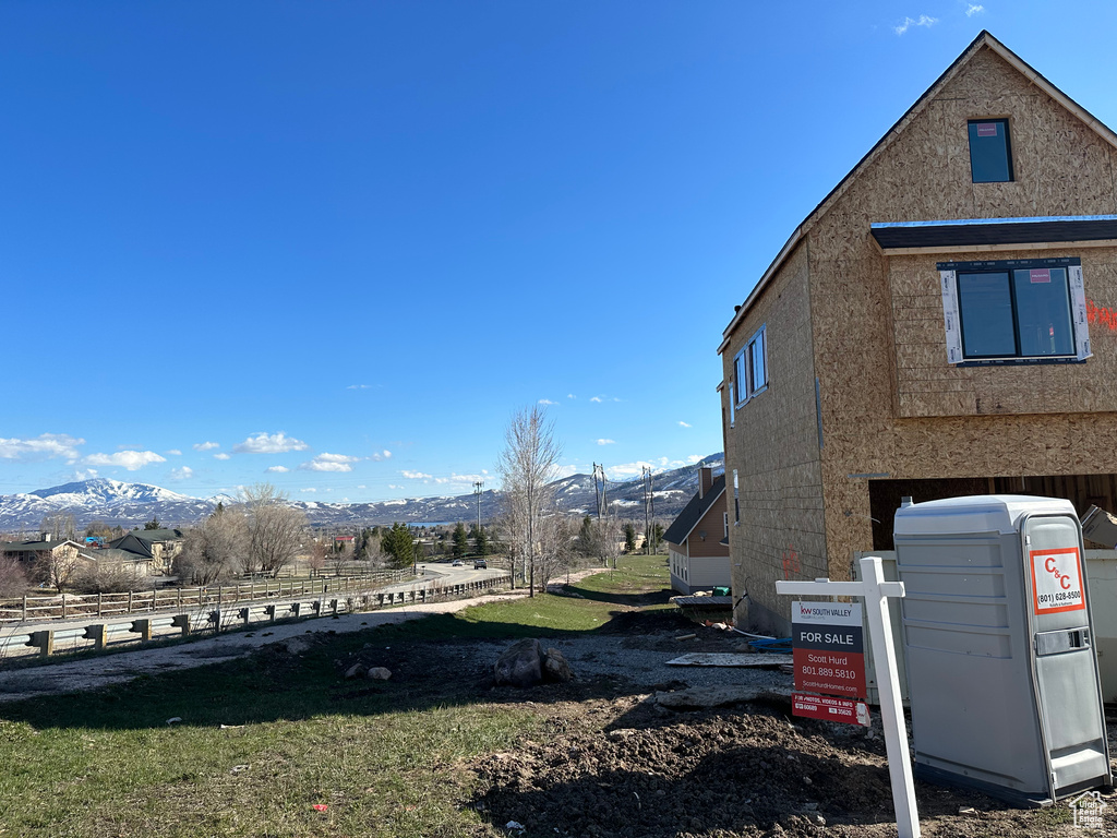 View of property exterior with a mountain view and a yard