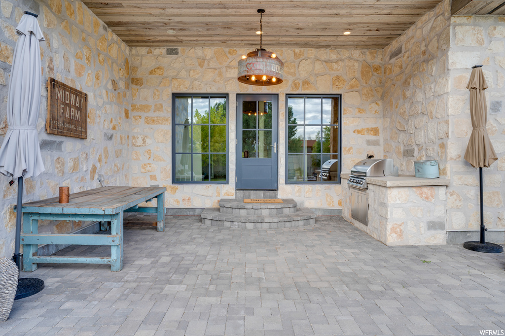 Doorway to property with a patio and an outdoor kitchen