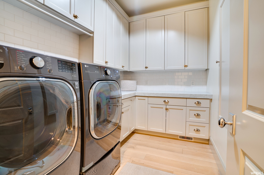 Washroom featuring independent washer and dryer and light hardwood floors