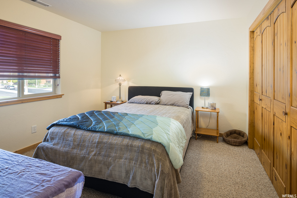Bedroom featuring light carpet