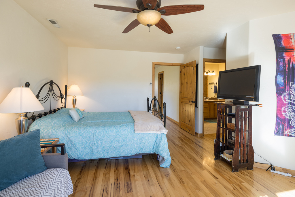 Hardwood floored bedroom with ceiling fan