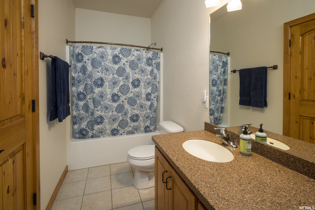 Full bathroom with shower / tub combo with curtain, oversized vanity, light tile flooring, and mirror
