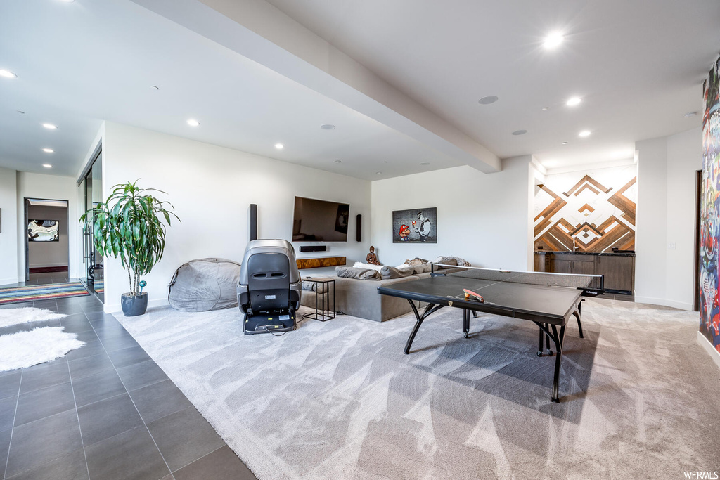 Recreation room with beamed ceiling and light tile floors