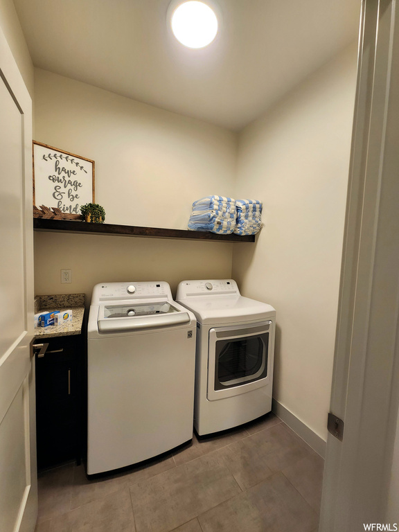Laundry area with washing machine and clothes dryer and light tile floors
