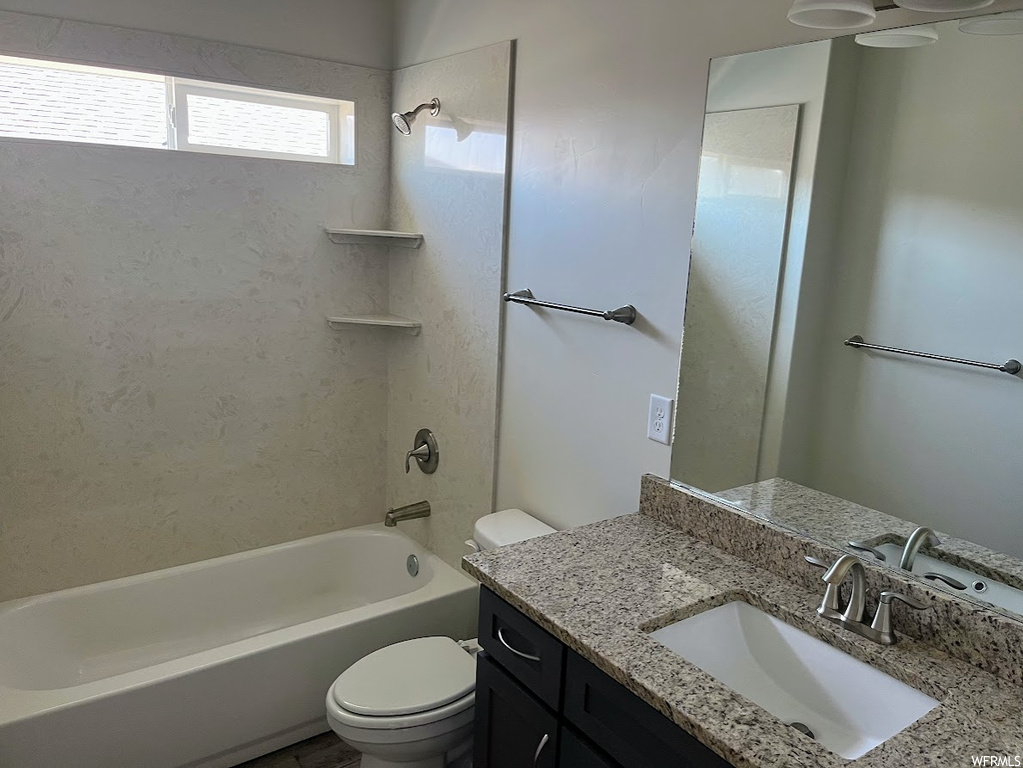 Full bathroom with washtub / shower combination, mirror, and vanity