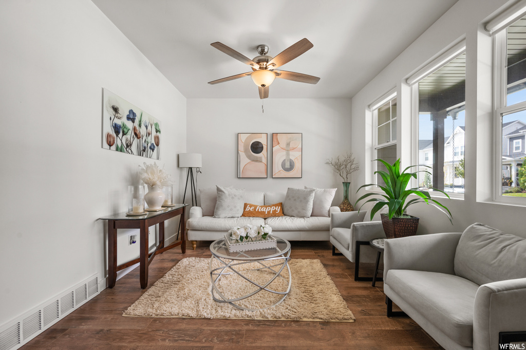 Living room featuring dark hardwood flooring and ceiling fan