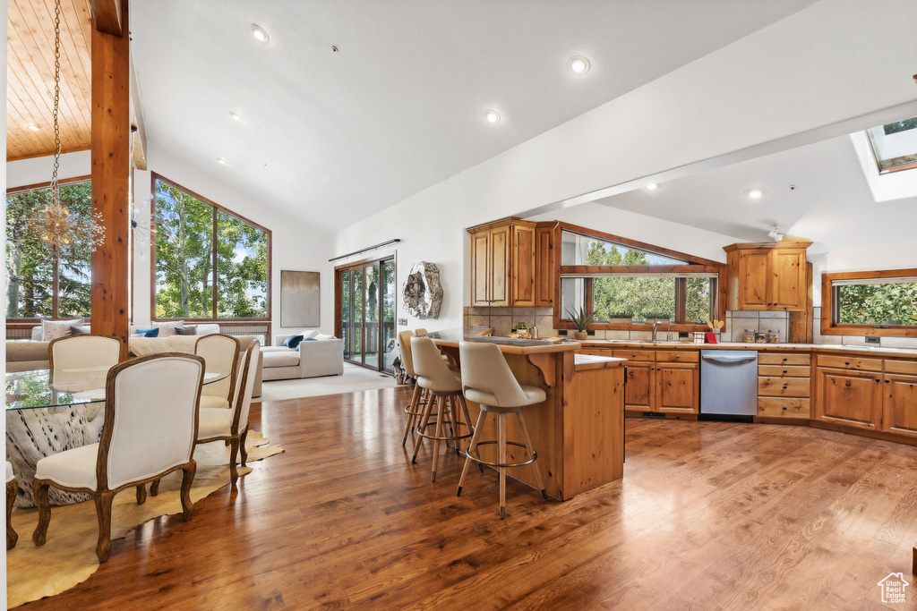 Kitchen with a skylight, plenty of natural light, light hardwood / wood-style flooring, and stainless steel dishwasher