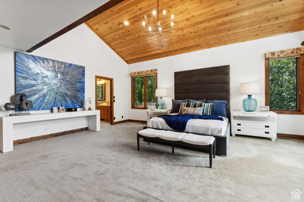 Carpeted bedroom with a notable chandelier, ensuite bathroom, high vaulted ceiling, and wooden ceiling