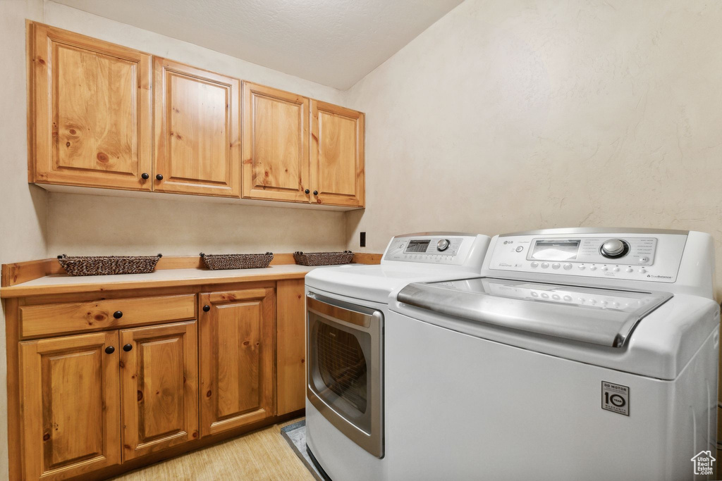 Washroom with separate washer and dryer and cabinets