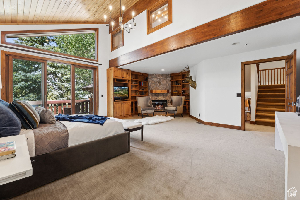 Bedroom featuring beam ceiling, wood ceiling, a stone fireplace, light carpet, and high vaulted ceiling