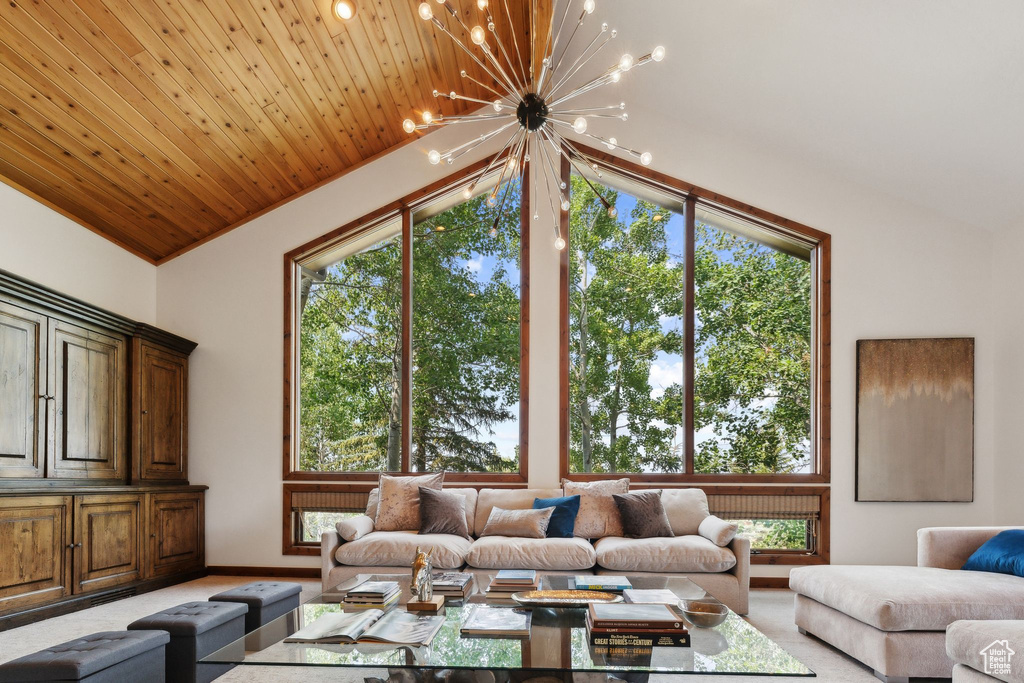 Carpeted living room featuring high vaulted ceiling, wooden ceiling, and a notable chandelier