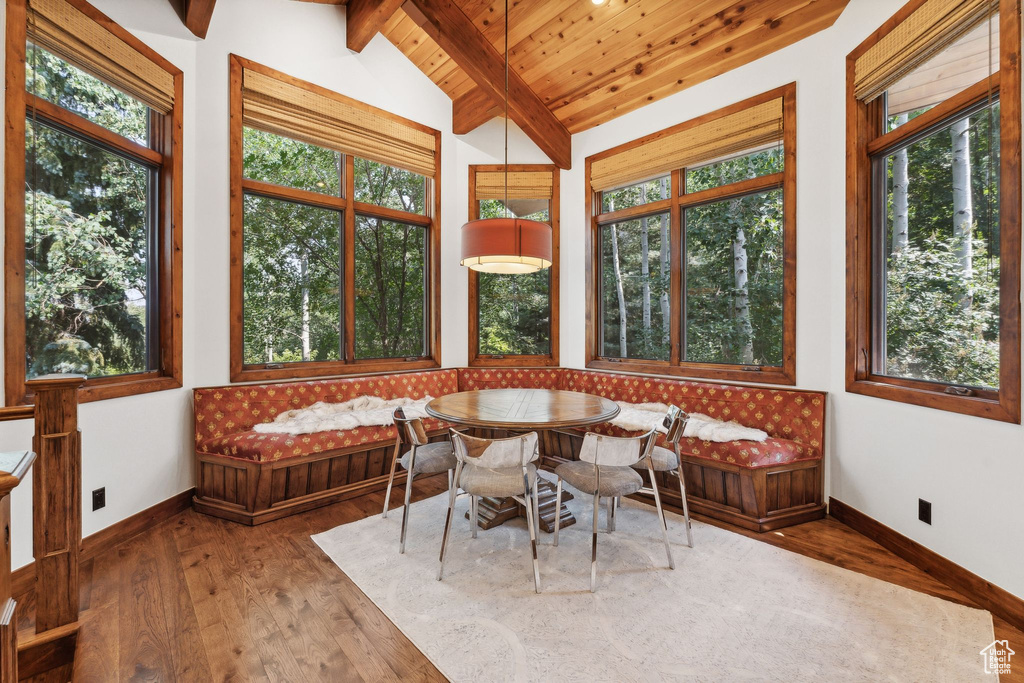 Sunroom featuring a wealth of natural light, vaulted ceiling with beams, and wood ceiling