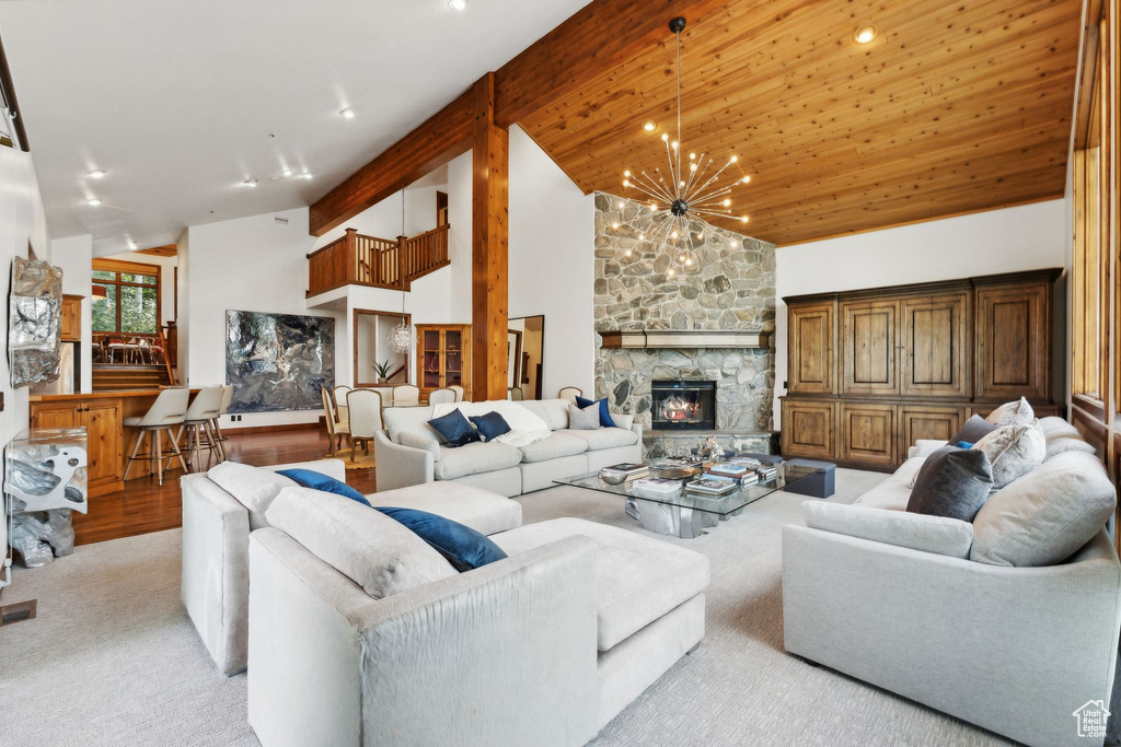 Living room featuring light hardwood / wood-style flooring, a fireplace, high vaulted ceiling, and a chandelier