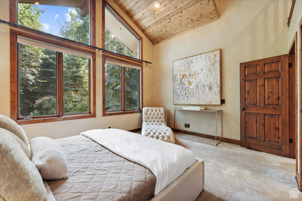 Bedroom featuring wood ceiling, high vaulted ceiling, and light colored carpet
