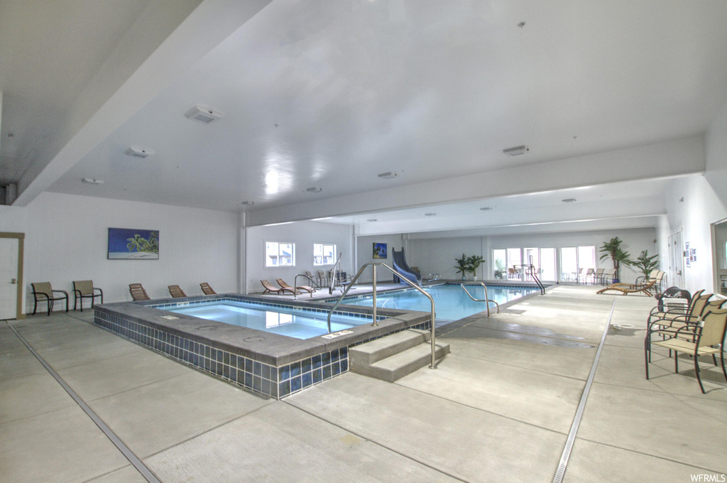 View of swimming pool featuring a patio and hot tub