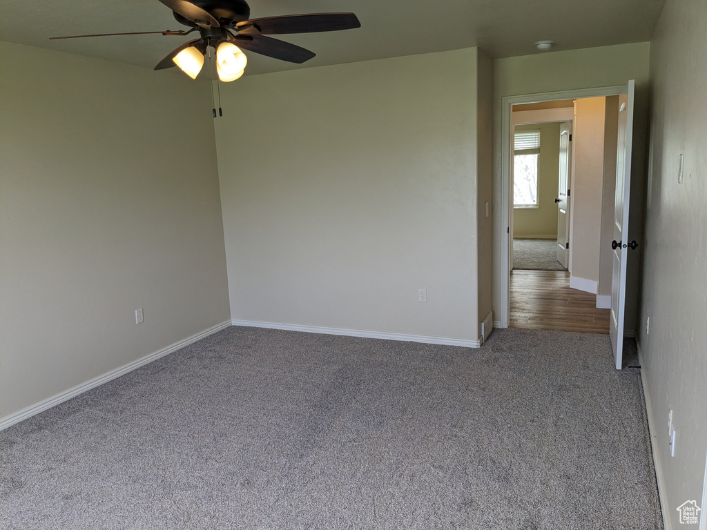 Empty room featuring hardwood / wood-style floors and ceiling fan