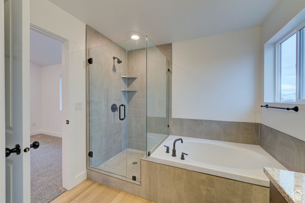 Bathroom featuring vanity, separate shower and tub, and hardwood / wood-style floors