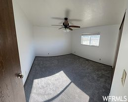 Spare room with carpet and ceiling fan