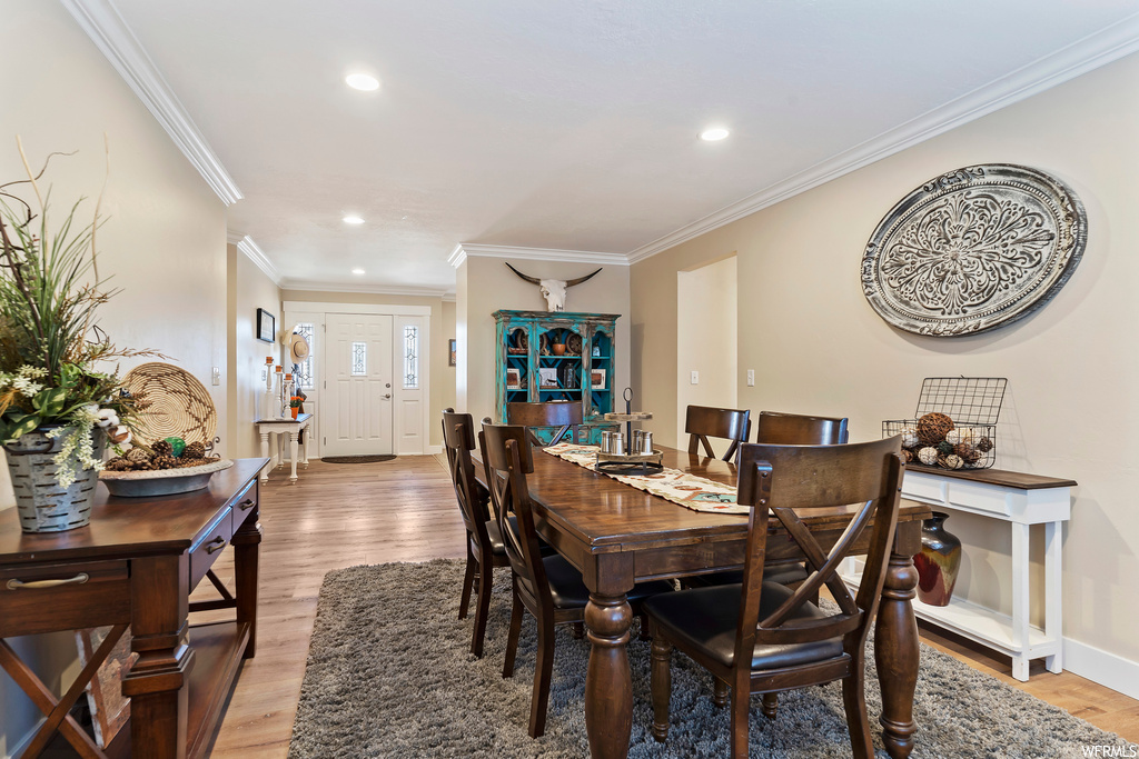 Wood floored dining room featuring crown molding