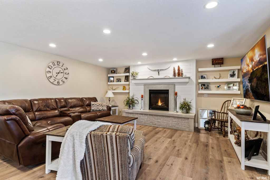 Hardwood floored living room featuring a fireplace and built in shelves