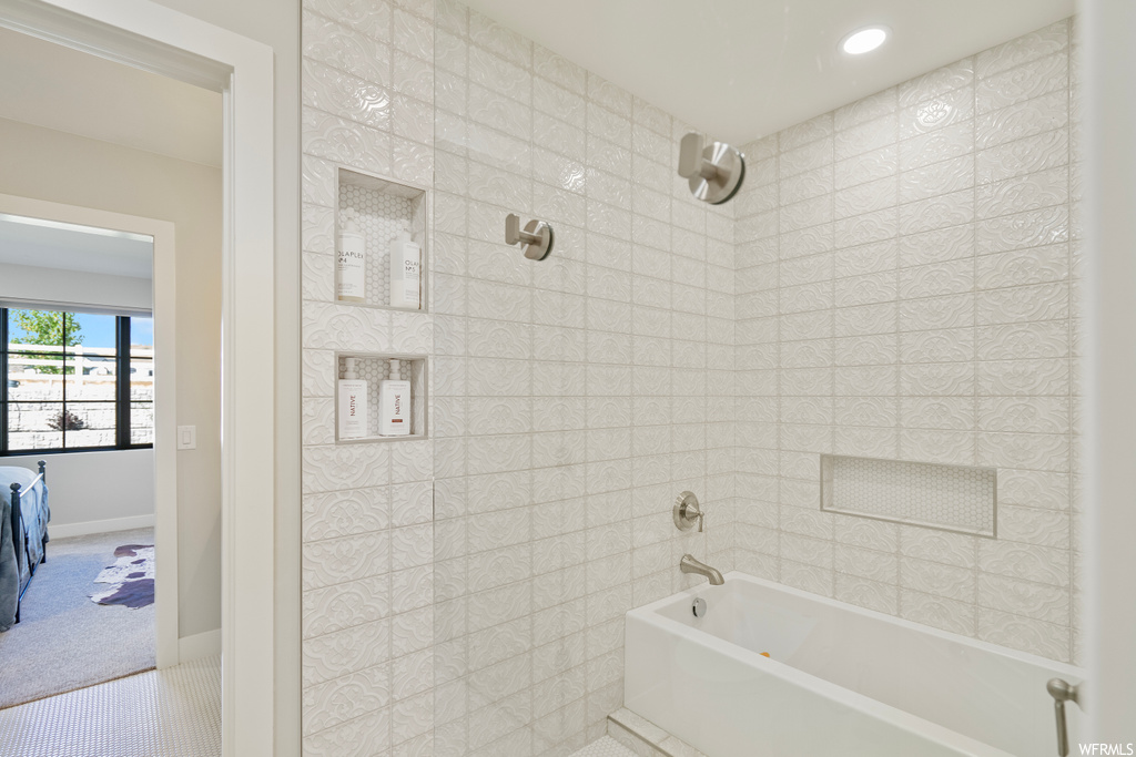 Bathroom featuring tiled shower / bath and light tile floors