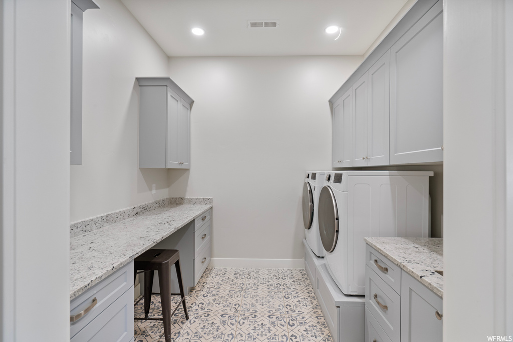 Washroom with independent washer and dryer and light tile flooring