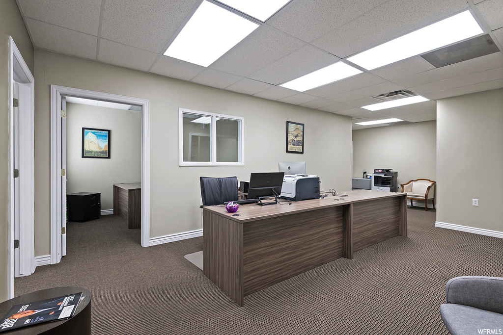 Office featuring a drop ceiling and dark carpet