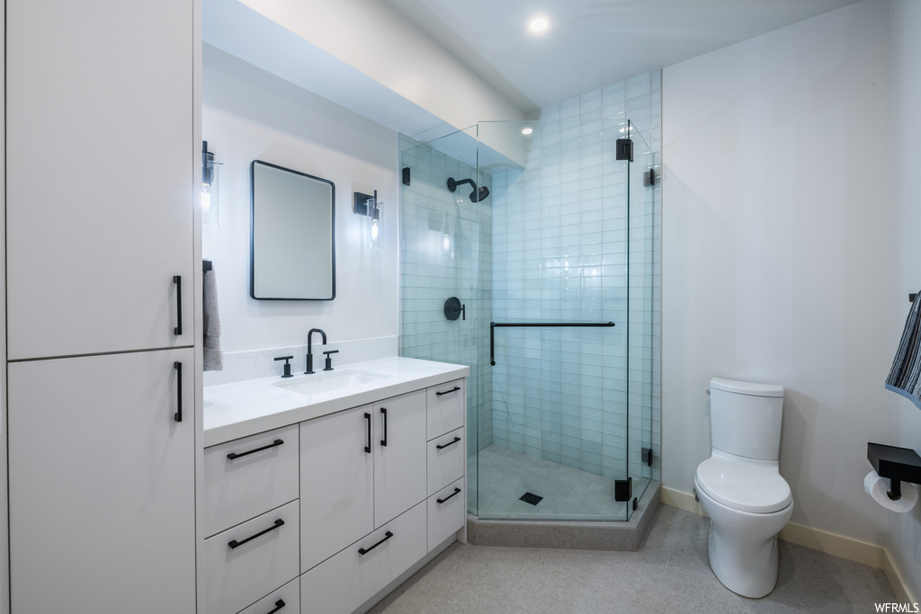 Bathroom with oversized vanity, mirror, and a shower with door