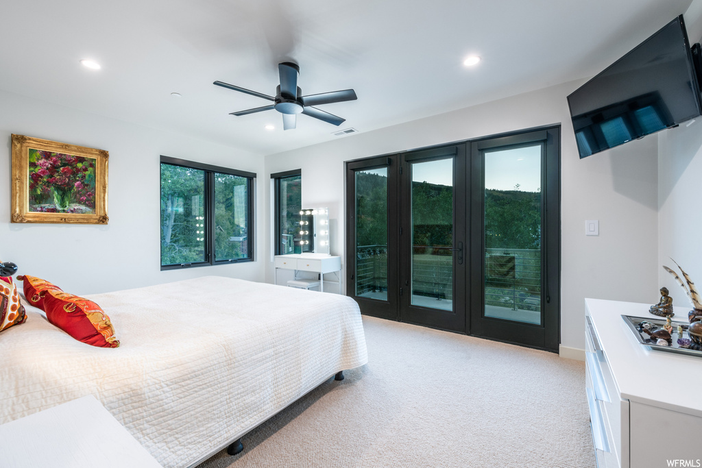 Bedroom featuring light carpet, french doors, and ceiling fan