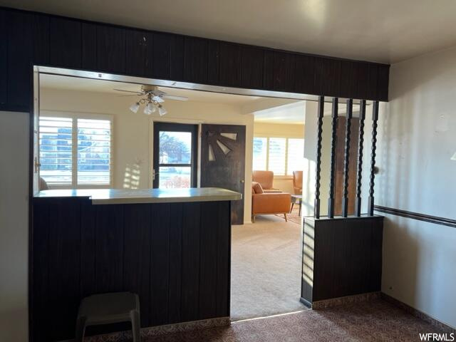 Kitchen with light carpet, light countertops, and ceiling fan