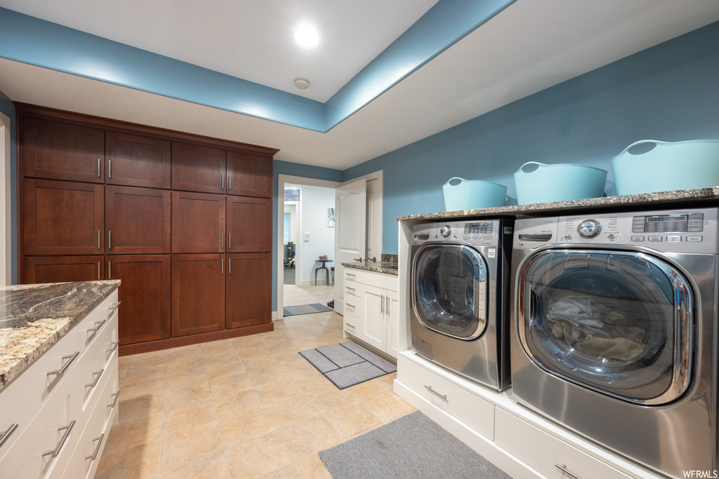 Washroom with washer and dryer and light tile flooring