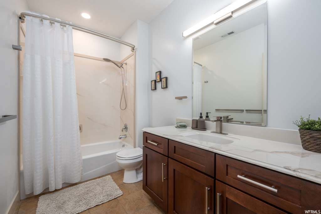 Full bathroom with shower / tub combo with curtain, oversized vanity, mirror, and light tile floors