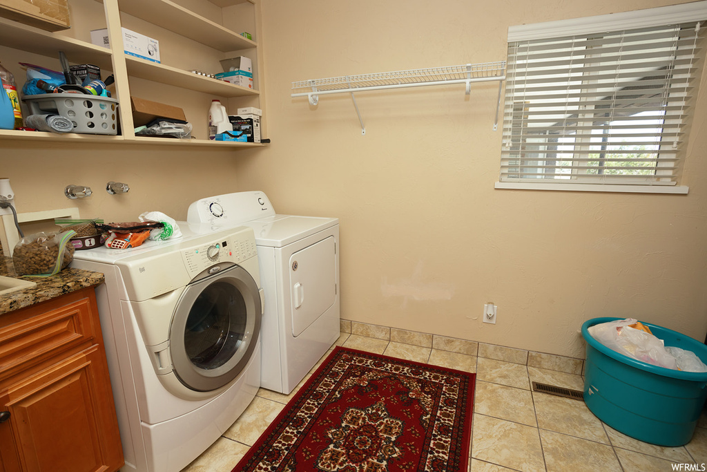 Laundry room featuring washer hookup, washing machine and clothes dryer, and light tile floors