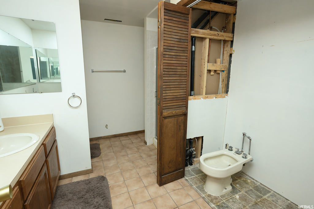Bathroom with tile floors, a bidet, and large vanity