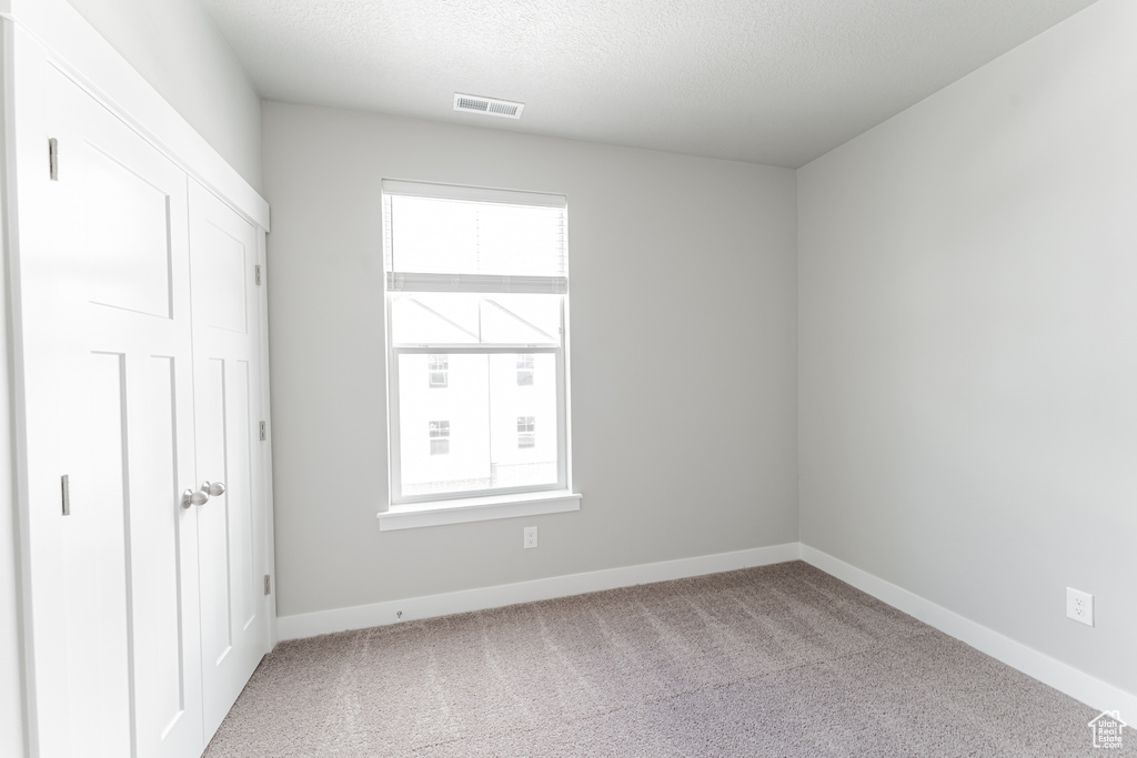 Unfurnished room with a healthy amount of sunlight and carpet