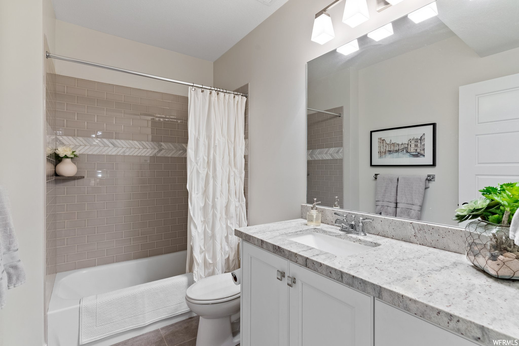 Full bathroom with shower / tub combo with curtain, vanity, tile flooring, and mirror