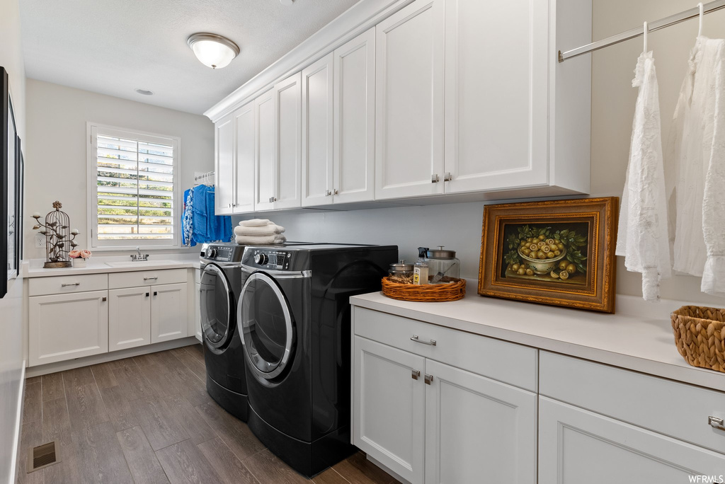 Laundry area featuring washer and dryer and hardwood floors
