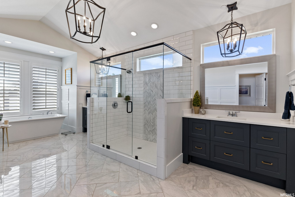 Bathroom featuring vanity, an enclosed shower, mirror, a wealth of natural light, vaulted ceiling, and light tile floors