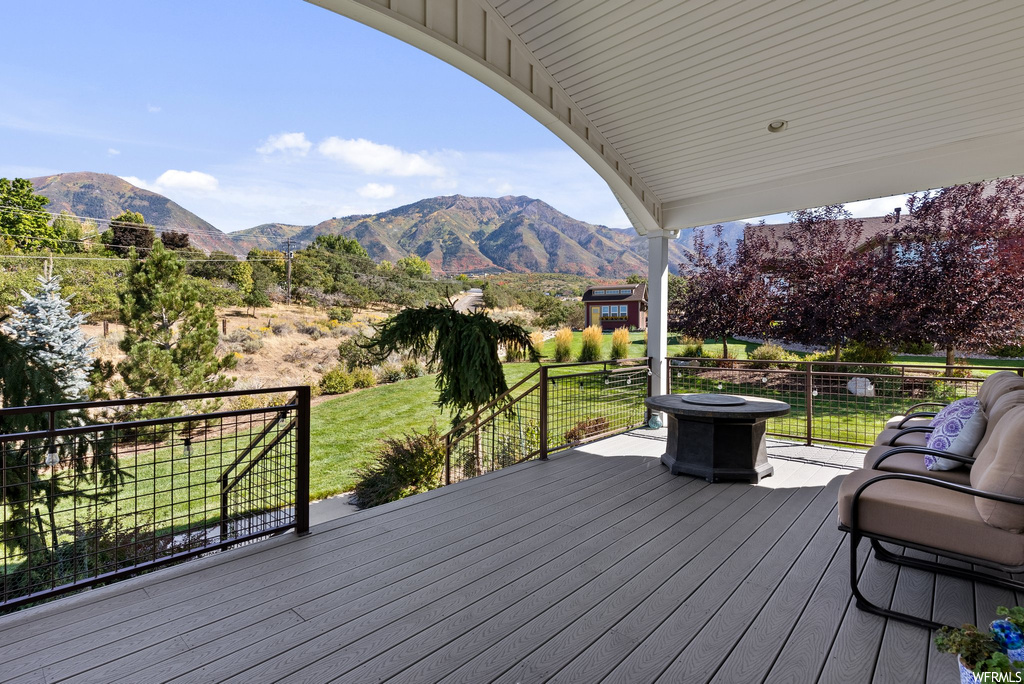 Deck with a lawn and a mountain view