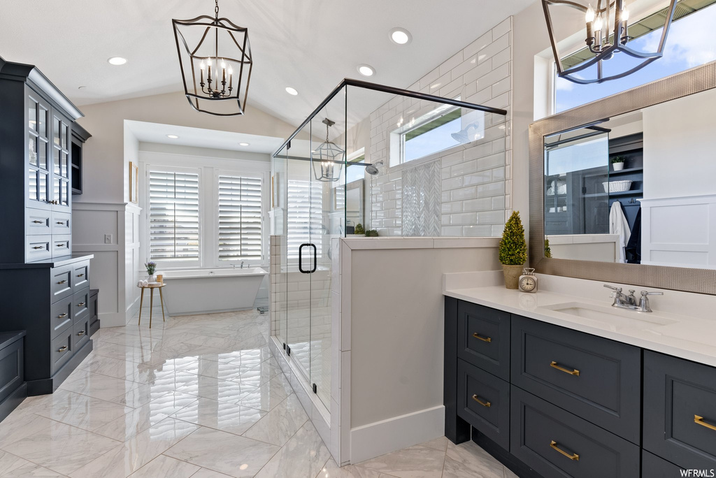 Bathroom featuring vanity, mirror, a shower with shower door, lofted ceiling, and light tile floors