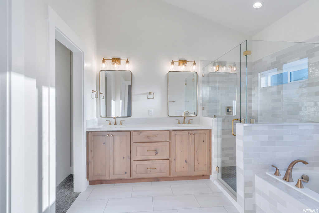Bathroom with separate shower and tub, mirror, dual large bowl vanity, and light tile floors