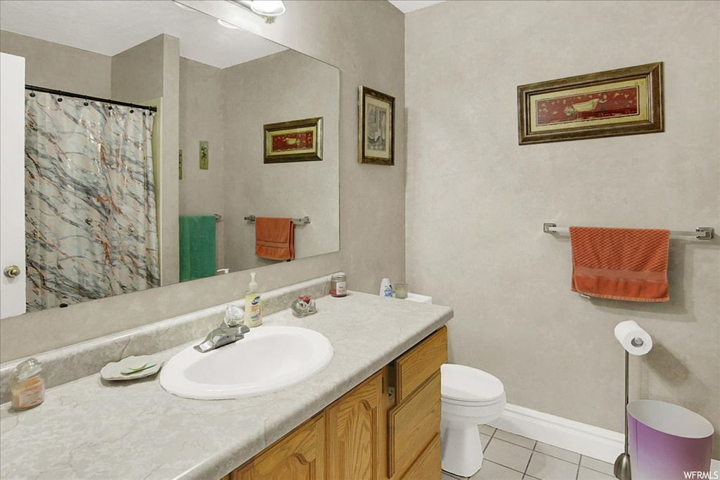 Bathroom with vanity, mirror, and light tile floors