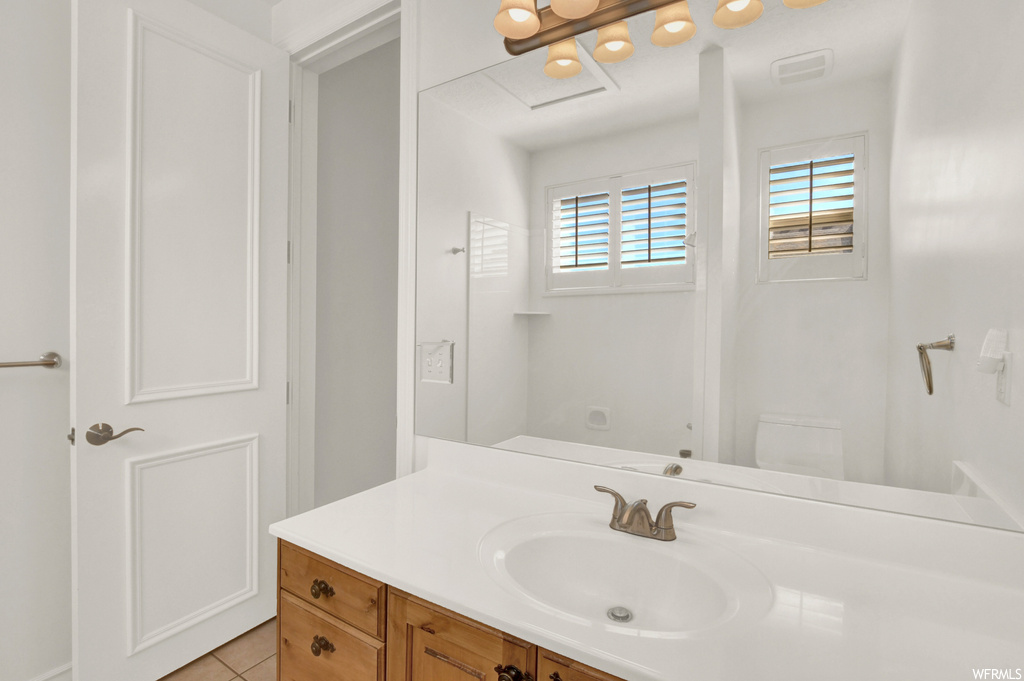 Bathroom featuring vanity, tile flooring, and mirror