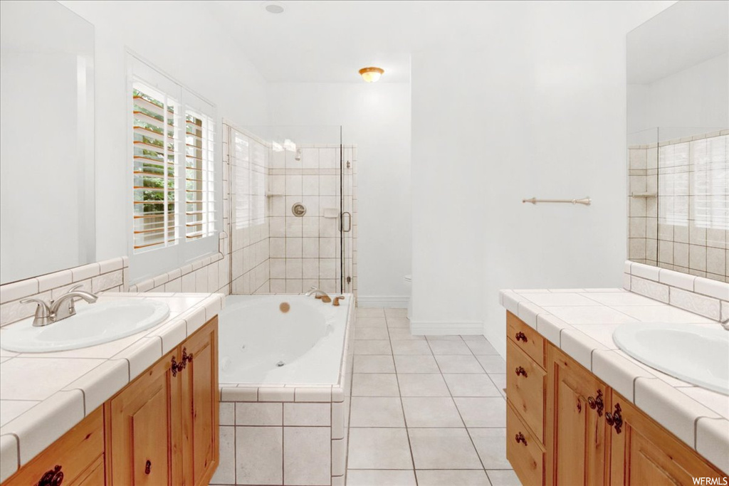 Bathroom with tile floors, shower with separate bathtub, and double vanity
