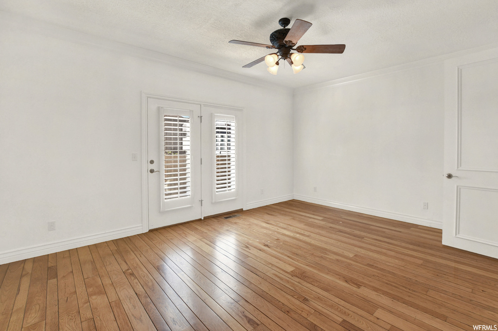 Unfurnished room featuring crown molding, light hardwood floors, and ceiling fan