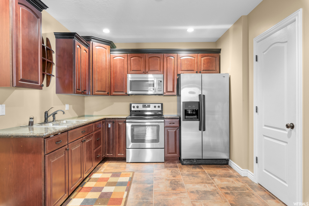 Kitchen featuring appliances with stainless steel finishes and light tile flooring