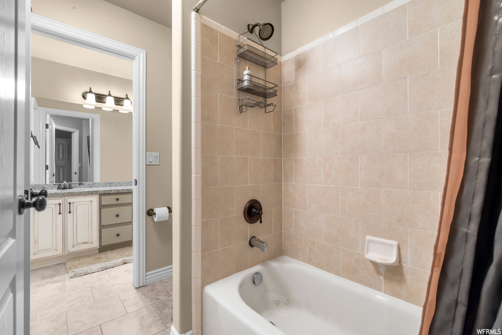 Bathroom with light tile flooring, shower / tub combo with curtain, mirror, and vanity