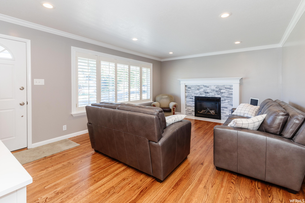 Hardwood floored living room featuring crown molding