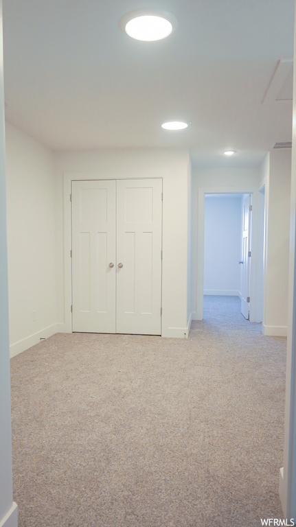 Interior space with light carpet and a closet